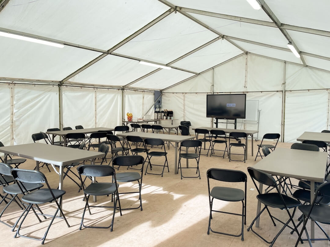 Inside the marquee at Avon Tyrrell Outdoor Centre with table and chairs, TV and tea and coffee facilities