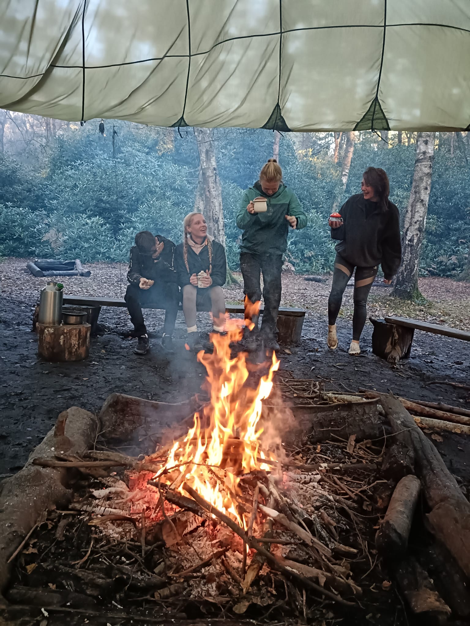apprentices around a campfire in the New Forest at Avon Tyrrell Outdoor Centre